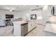 Bright kitchen featuring an island with seating, stainless steel appliances, and access to a cozy living room at 10381 Tupper Cay Dr, San Antonio, FL 33576