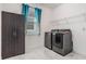 Bright laundry room featuring a modern washer and dryer set, storage cabinet, and a window at 10381 Tupper Cay Dr, San Antonio, FL 33576