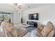 Inviting living room features tile floors, neutral color scheme, plush sofas, and a modern entertainment center at 10381 Tupper Cay Dr, San Antonio, FL 33576