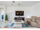 Bright living room with tile floors, a modern entertainment center, and comfortable seating at 10381 Tupper Cay Dr, San Antonio, FL 33576