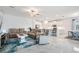 Open-concept living room with tile floors, plush sofas, kitchen with stainless steel appliances in background at 10381 Tupper Cay Dr, San Antonio, FL 33576