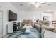 Cozy living room featuring plush sofas, a modern entertainment center, and lots of natural light at 10381 Tupper Cay Dr, San Antonio, FL 33576