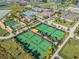Aerial view of community tennis courts with meticulously manicured landscaping at 10381 Tupper Cay Dr, San Antonio, FL 33576