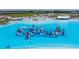 Aerial view of the lagoon, and its expansive inflatable waterpark and clear blue swimming area at 10381 Tupper Cay Dr, San Antonio, FL 33576