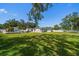 Backyard view of landscaped lawn, patio, and pool at 10875 131St St, Largo, FL 33774