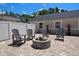 Backyard with brick patio featuring a fire pit, chairs, and privacy fence at 10875 131St St, Largo, FL 33774