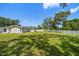 Expansive backyard featuring a well-maintained lawn, surrounded by a white fence and mature trees at 10875 131St St, Largo, FL 33774