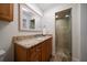Bathroom featuring wood cabinets, granite counters, and a tiled walk-in shower at 10875 131St St, Largo, FL 33774