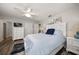 Bright bedroom with a white ceiling fan, a blue accent pillows, and wood-look flooring at 10875 131St St, Largo, FL 33774