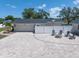 Paver driveway with a fire pit and seating area in front of the garage and house at 10875 131St St, Largo, FL 33774