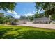 Spacious backyard area including lawn and patio, with a white fence, fire pit, and two car garage at 10875 131St St, Largo, FL 33774