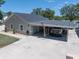 Exterior of a home featuring a covered parking area, a garage, and well-maintained landscaping at 10875 131St St, Largo, FL 33774
