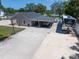 Single-story home featuring covered parking, RV, basketball hoop, and a spacious concrete driveway at 10875 131St St, Largo, FL 33774