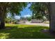 Sprawling lawn leads to single-story homes with brick driveway, privacy fence, and beautiful landscaping at 10875 131St St, Largo, FL 33774