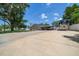 Single-story home with covered parking, RV, basketball hoop, and a spacious concrete driveway at 10875 131St St, Largo, FL 33774
