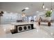 Kitchen island includes a hidden electrical outlet on a marble countertop, surrounded by modern lighting at 10875 131St St, Largo, FL 33774