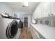 Bright laundry room featuring white cabinetry, quartz countertops, and modern appliances at 10875 131St St, Largo, FL 33774
