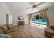 Living room with sliding glass doors to the pool, hardwood floors, and ceiling fan at 10875 131St St, Largo, FL 33774