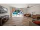 Open living room featuring hardwood floors and sliding glass doors to the pool area at 10875 131St St, Largo, FL 33774