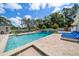 Inviting backyard pool area featuring a relaxing lounge area, landscaping, and tiled patio at 10875 131St St, Largo, FL 33774