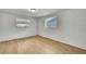Bright bedroom with natural light, light wood flooring, and two windows at 11130 White Oak Ln, Port Richey, FL 34668