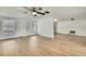 Spacious living room featuring light wood flooring, white walls, and a modern ceiling fan at 11130 White Oak Ln, Port Richey, FL 34668