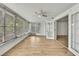 Bright sunroom features wood-look flooring, multiple windows with backyard views and access to the yard at 11130 White Oak Ln, Port Richey, FL 34668