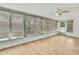 Bright sunroom features wood-look flooring, multiple windows with views and a ceiling fan at 11130 White Oak Ln, Port Richey, FL 34668