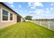 Expansive backyard with lush green grass, white picket fence, and beautiful lake view at 11522 Sunburst Marble Rd, Riverview, FL 33579