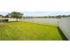 Lush green lawn extending to a white fence bordering a serene lake at 11522 Sunburst Marble Rd, Riverview, FL 33579