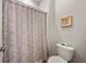 Bathroom featuring floral patterned shower curtain, toilet and wall art at 11522 Sunburst Marble Rd, Riverview, FL 33579