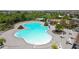 Aerial view of a large community pool with ample seating, palm trees, and a playground nearby at 11522 Sunburst Marble Rd, Riverview, FL 33579