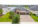 Beautiful single Gathering home featuring an attached three-car garage, lush landscaping, and a serene lake view at 11522 Sunburst Marble Rd, Riverview, FL 33579