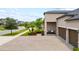 Inviting front yard with manicured landscaping, a brick paver driveway, and a charming covered entryway at 11522 Sunburst Marble Rd, Riverview, FL 33579