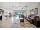 Open-concept living room features tile floors, a ceiling fan, and sliding glass doors leading to the outdoor space at 11522 Sunburst Marble Rd, Riverview, FL 33579