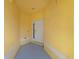 Welcoming, yellow, covered entryway with a sturdy white door and neutral grey flooring that invites you inside at 11559 Captiva Kay Dr, Riverview, FL 33569