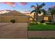Charming yellow home featuring a two-car garage, well-manicured lawn, and mature palm trees against a colorful sunset backdrop at 11559 Captiva Kay Dr, Riverview, FL 33569