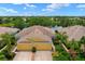 Stunning yellow home features a two-car garage, lovely landscaping, and a serene pond view, perfect for tranquil living at 11559 Captiva Kay Dr, Riverview, FL 33569
