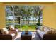 Screened in lanai featuring comfortable seating with a peaceful lake view at 11559 Captiva Kay Dr, Riverview, FL 33569