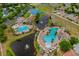 Aerial view of a community pool area featuring two large pools, a splash pad, and lakeside fountains at 11559 Captiva Kay Dr, Riverview, FL 33569