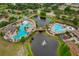 An aerial perspective highlights the community's dual pool areas connected by a charming bridge and surrounded by lush greenery at 11559 Captiva Kay Dr, Riverview, FL 33569