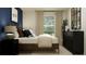 Comfortable bedroom featuring a wood-trimmed bed, neutral tones, and dark wood dresser at 11694 Brae Way, Dade City, FL 33525