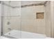 Bathroom showcasing tiled walls, a glass shower door, and a built-in shower niche for storage at 12946 116Th St, Largo, FL 33778