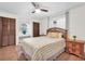 Bedroom with tiled floors, ceiling fan, wood closets, and a decorative bed with striped bedding at 12946 116Th St, Largo, FL 33778
