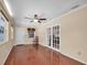 Cozy sunroom with hardwood floors, ceiling fan, chair, and doors to the living area at 12946 116Th St, Largo, FL 33778