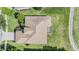 Birds eye view of a home with large brown roof in a yard with trees nearby golf course at 13238 Chipout Ln, Hudson, FL 34669