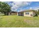 Expansive backyard with a screened patio and well-maintained lawn and an adjacent home at 13238 Chipout Ln, Hudson, FL 34669