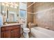 Well-lit bathroom featuring tiled walls, a tub and shower combination, and a vanity with granite countertop at 13238 Chipout Ln, Hudson, FL 34669