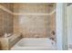 Clean bathroom showcasing tiled walls with a bench and a shower over the tub at 13238 Chipout Ln, Hudson, FL 34669