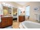 Elegant bathroom with double vanities, granite counters, and a soaking tub at 13238 Chipout Ln, Hudson, FL 34669